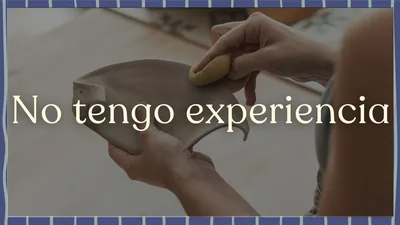Manos amasando barro sobre una mesa de trabajo